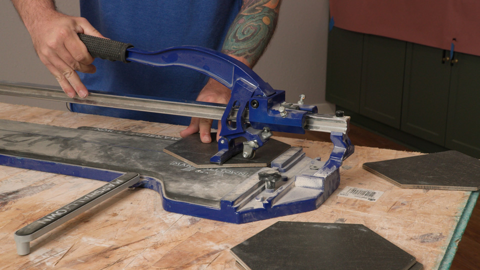 man using the MARSHALLTOWN Pro Tile Cutter to score and snap tile